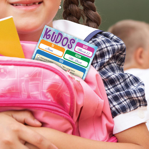 little girl holding a pink backpack with a Kudos notepad